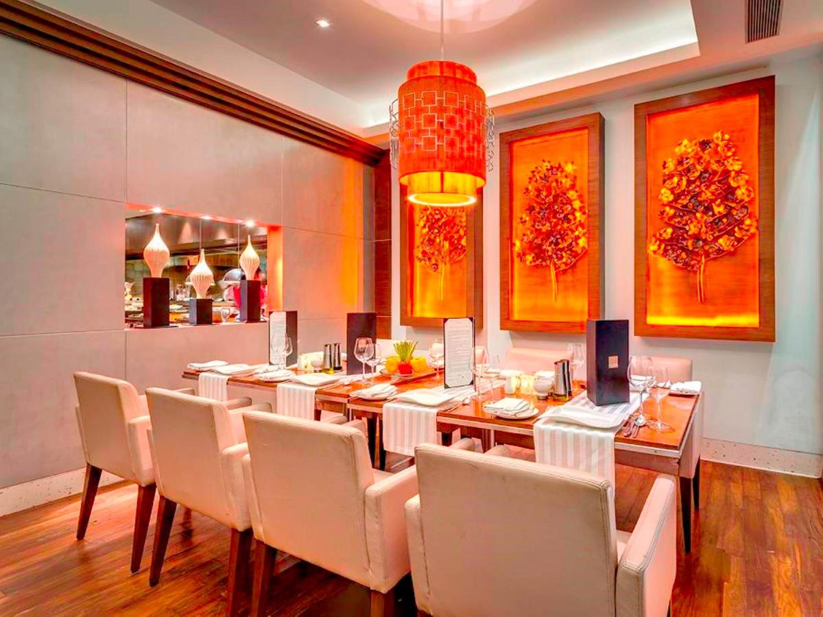 a dining room with a long table and chairs at Hotel Hindusthan International, Kolkata in Kolkata