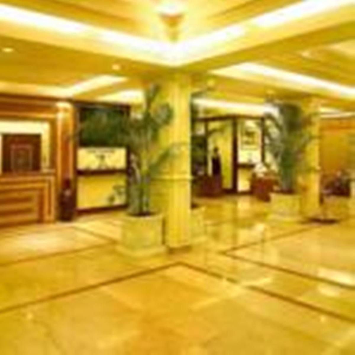 a large room with a lobby with columns and ceilings at Hotel Hindusthan International, Kolkata in Kolkata