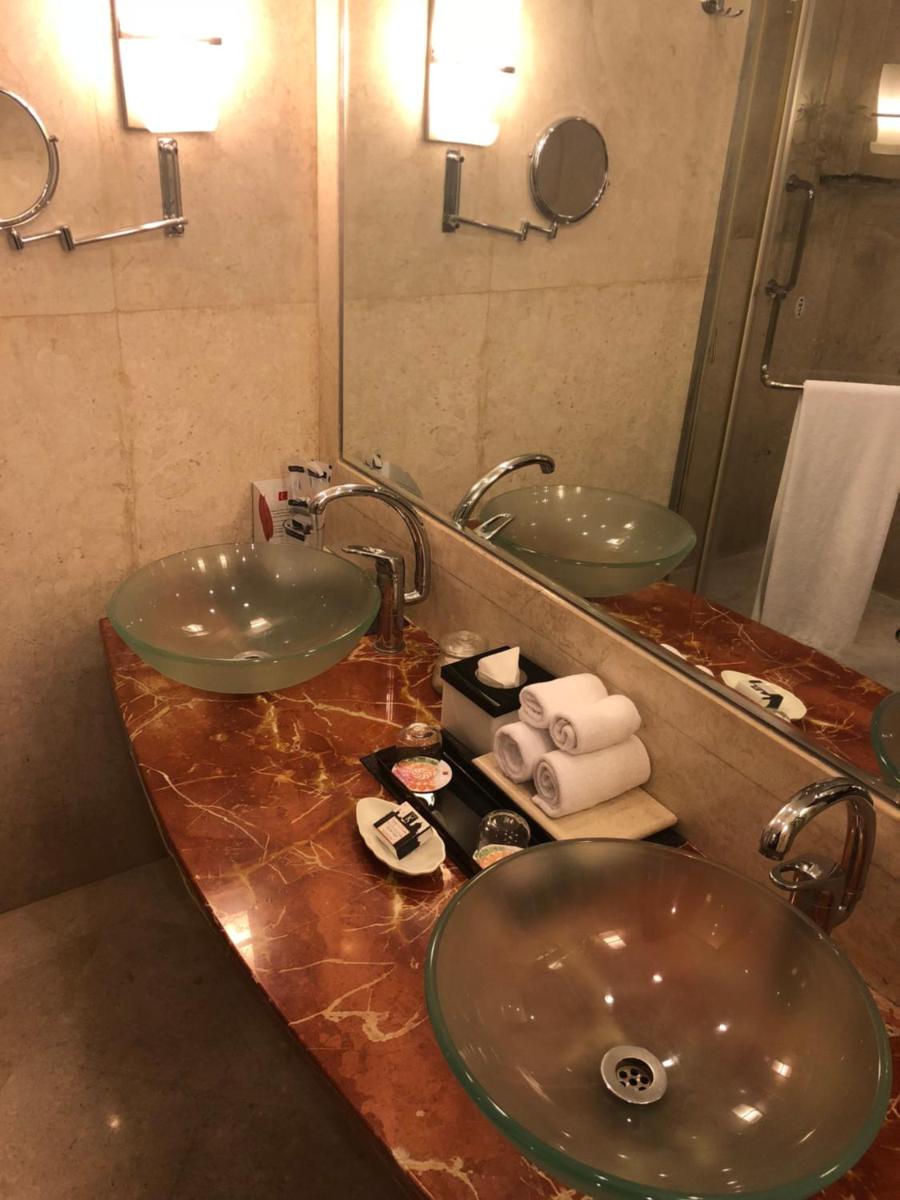 a bathroom with two sinks and a mirror at The Lalit Ashok in Bengaluru a bathroom with two sinks and a mirror at The Lalit Ashok in Bengaluru