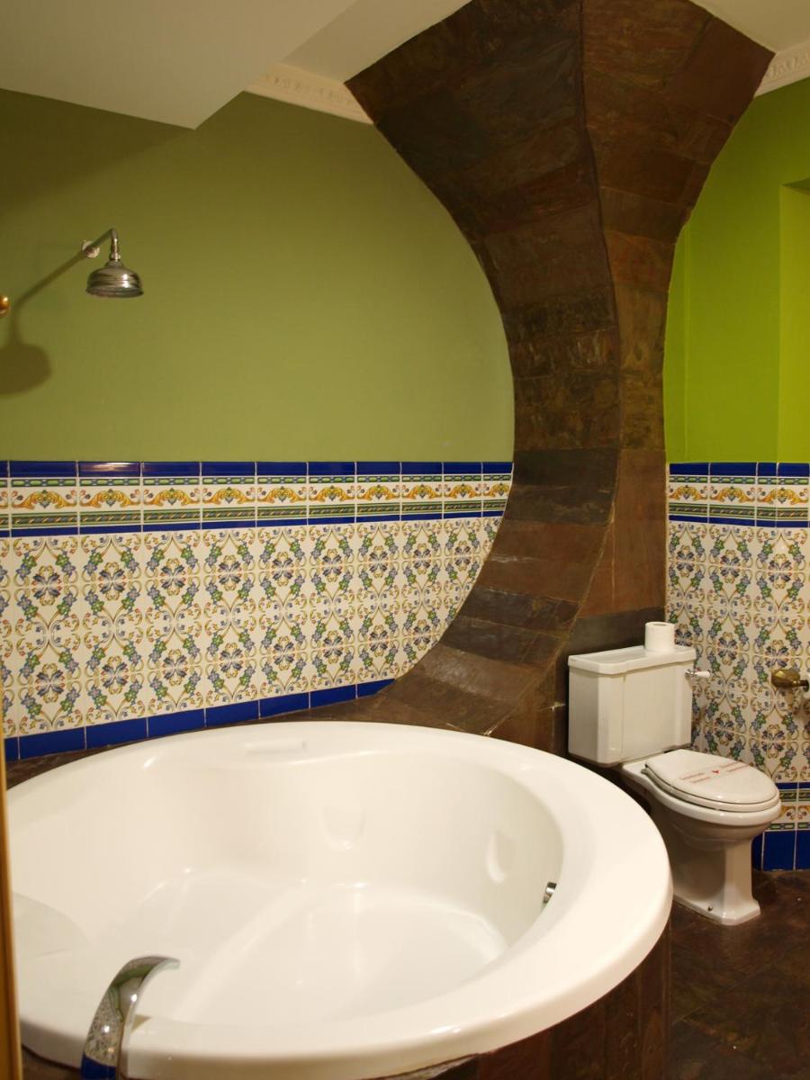 Un baño con bañera blanca y un inodoro. en Posada del Indiano, en Cidones