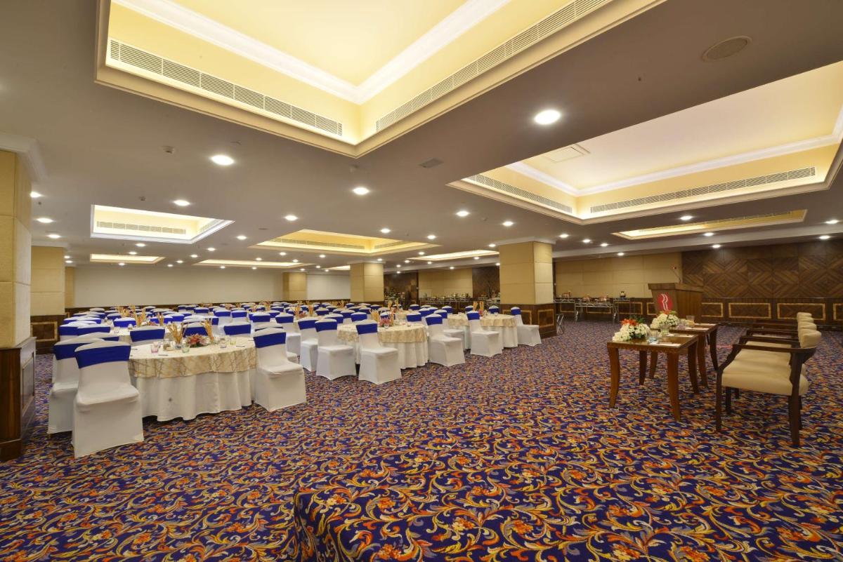 a banquet hall with tables and chairs in a room at Ramada Plaza Chennai in Chennai