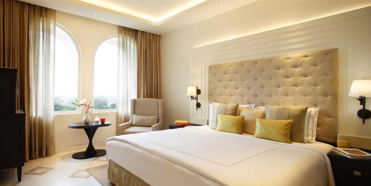 a bedroom with a large white bed and a window at Taj Ganges Varanasi in Varanasi