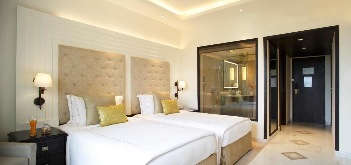a bedroom with two large white beds in a room at Taj Ganges Varanasi in Varanasi