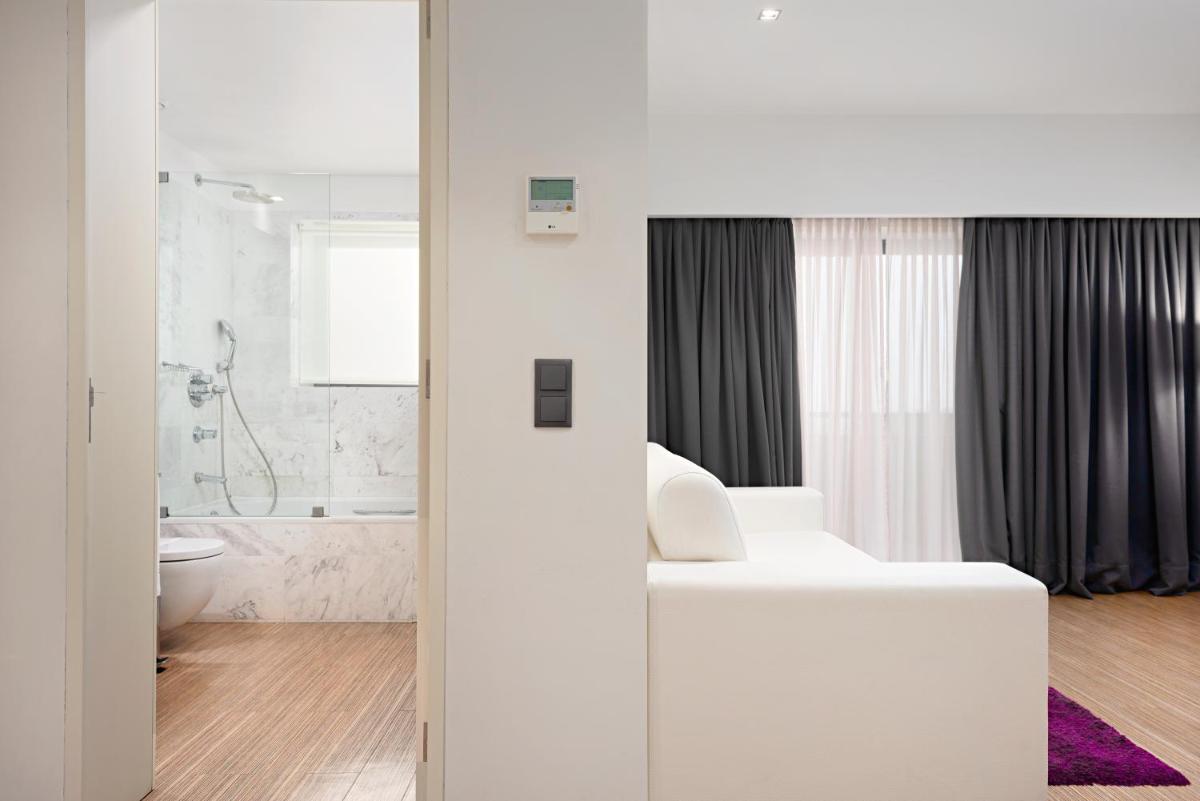 um banheiro branco com um vaso sanitário e uma pia em Hotel dos Zimbros em Sesimbra um banheiro branco com um vaso sanitário e uma pia em Hotel dos Zimbros em Sesimbra
