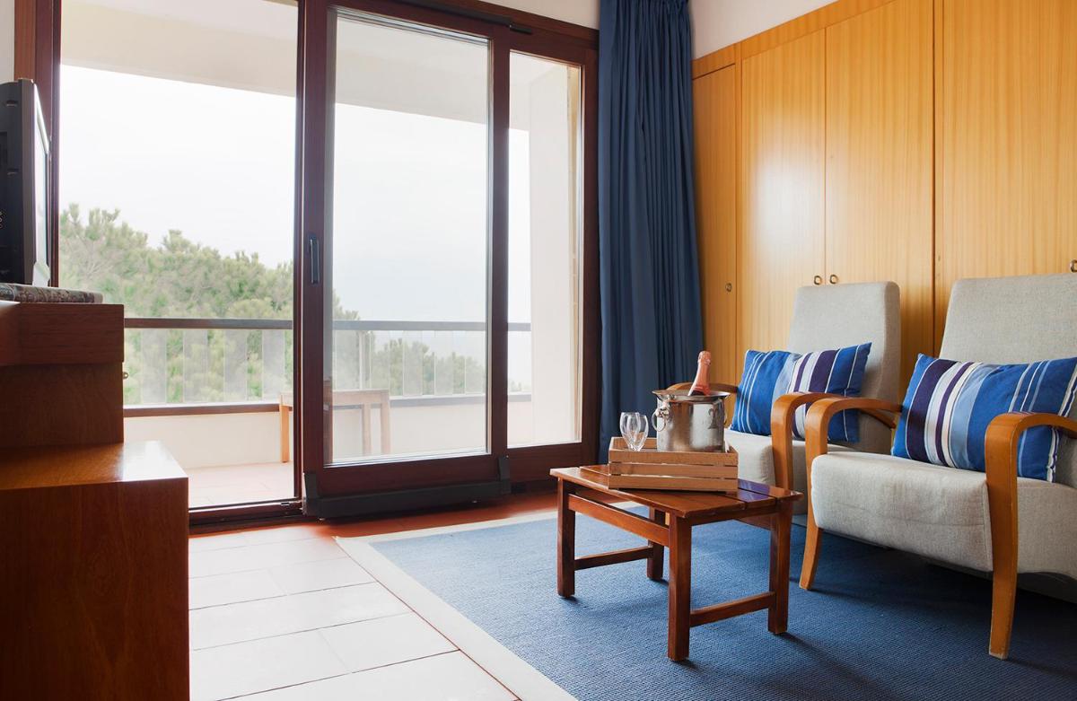 una sala de estar con un sofá y una mesa en Almadraba Park Hotel, en Roses