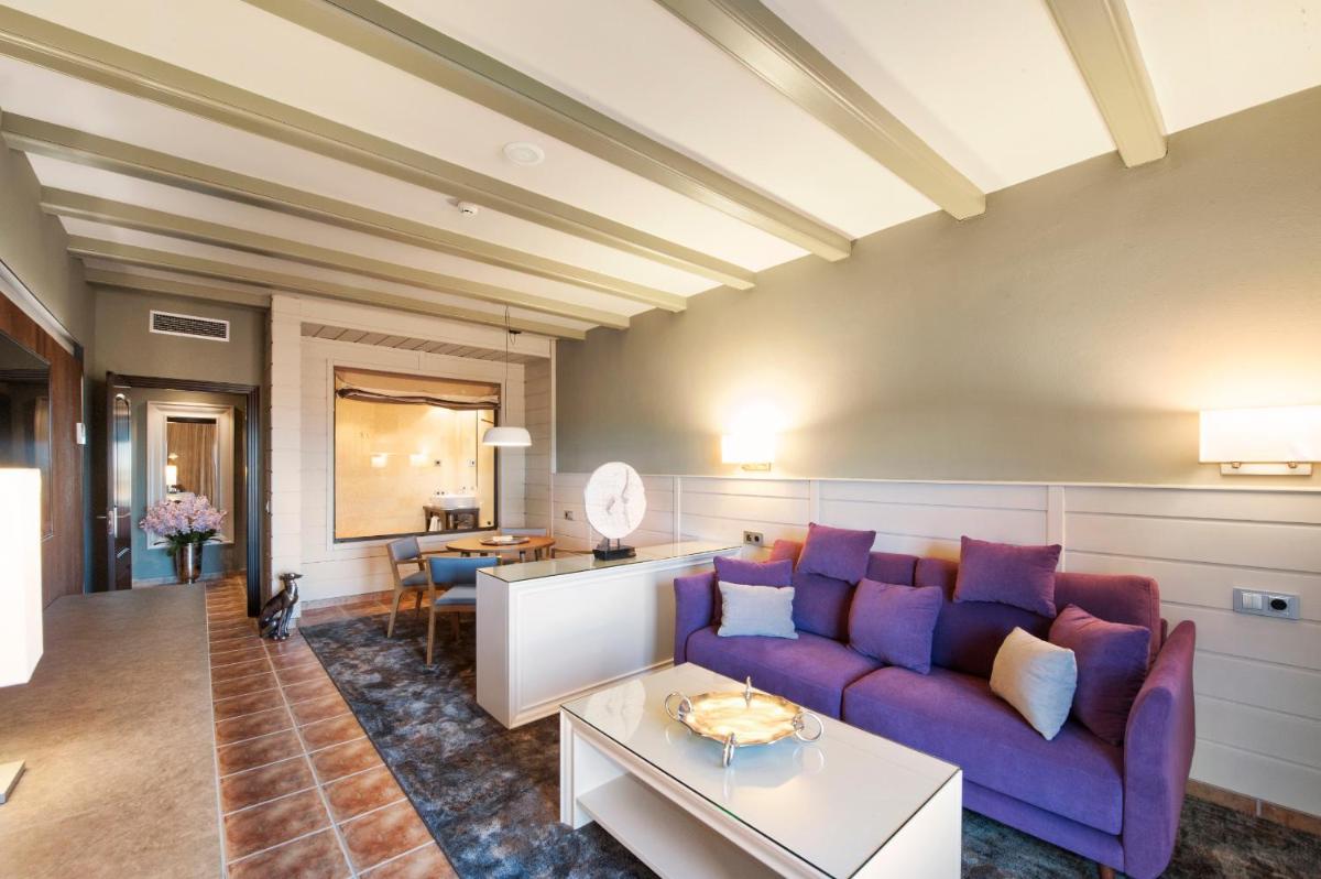 Una sala de estar con un sofá morado y una mesa. en Hotel La Caminera Club de Campo, en Torrenueva