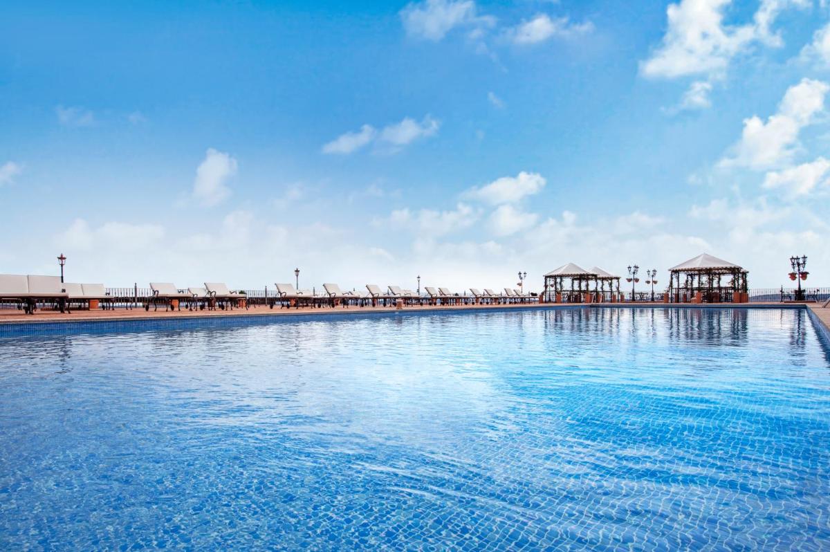 una gran masa de agua con un muelle al fondo en Hotel La Caminera Club de Campo, en Torrenueva