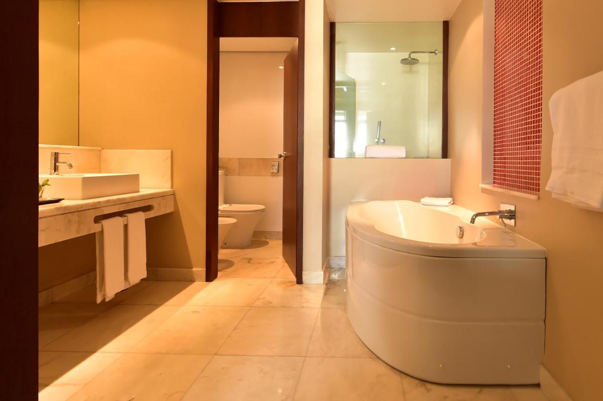 um banheiro com banheira, vaso sanitário e pia em Pestana Casino Park Hotel & Casino no Funchal