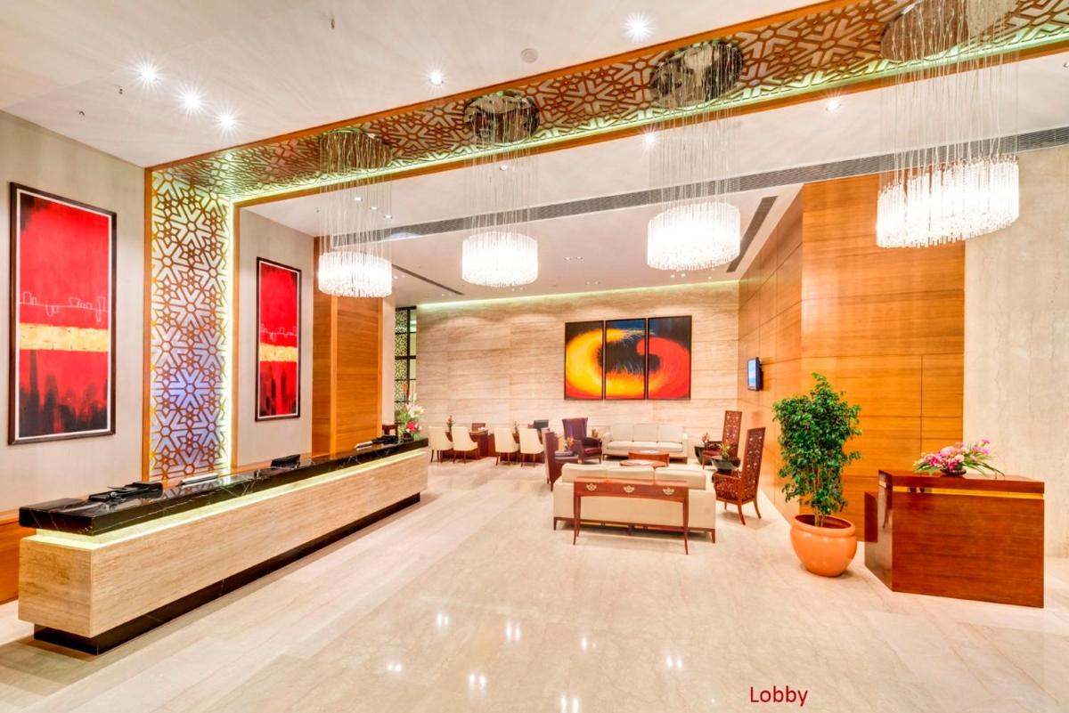 a lobby of a hotel with a table and chairs at Pride Plaza Hotel, Kolkata in Kolkata