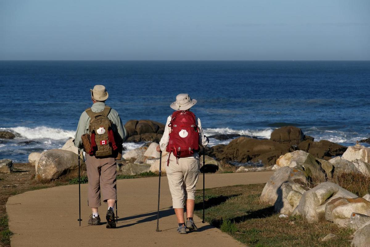 duas pessoas a caminhar num caminho a olhar para o oceano em Hotel Meira em Vila Praia de Âncora