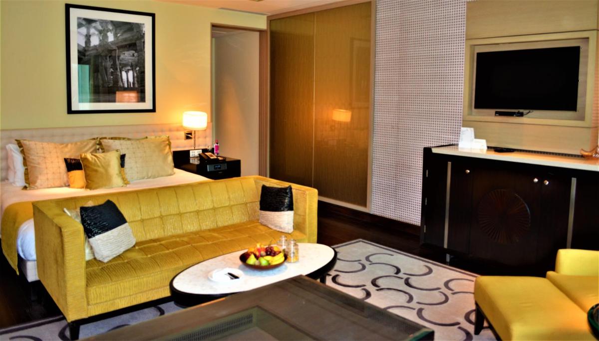 a hotel room with a couch and a bed at Taj Santacruz in Mumbai