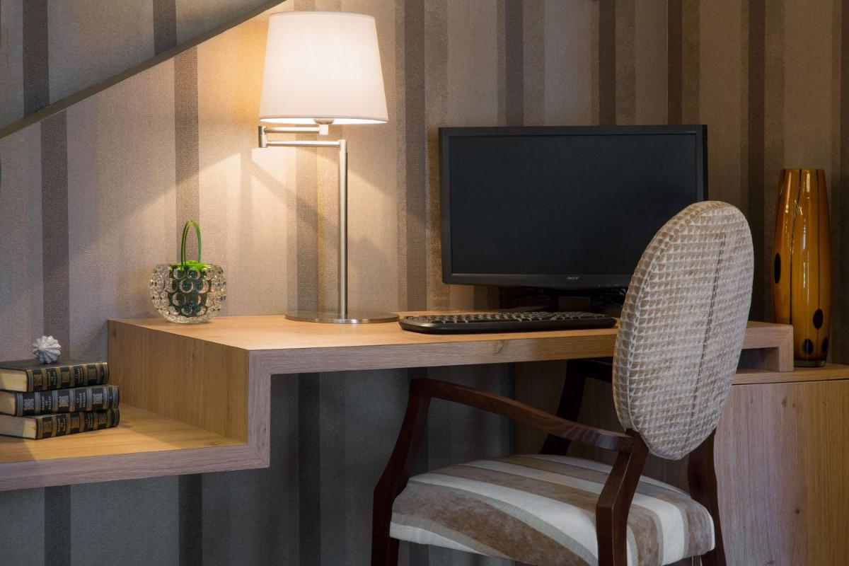 Télévision ou salle de divertissement dans l'établissement Hôtel Le Rive Droite & SPA