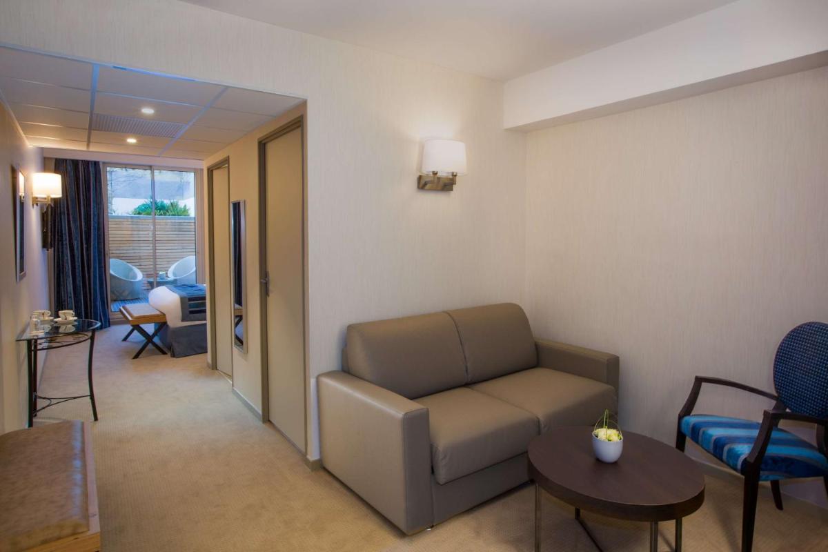 Coin salon dans l'établissement Hôtel Le Rive Droite & SPA