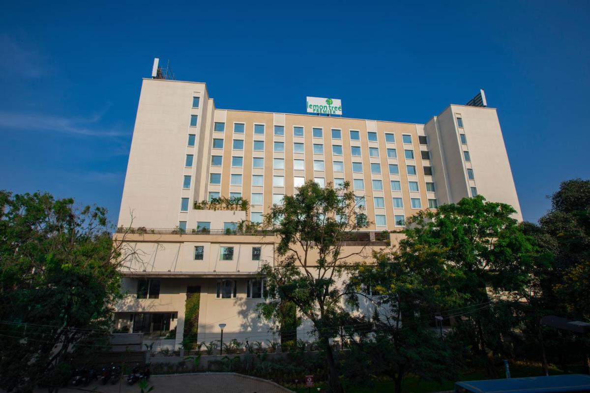 a large white building with a sign on top of it at Lemon Tree Premier City Center Pune in Pune