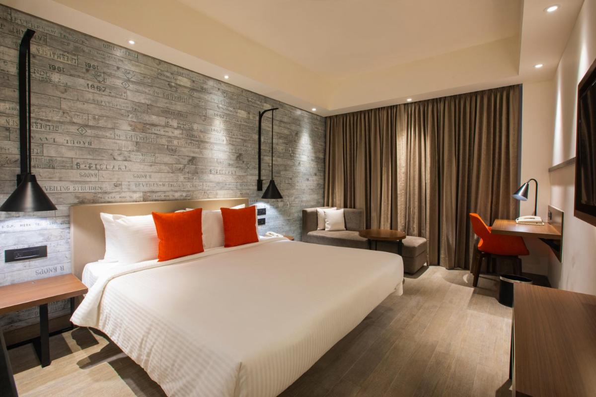 a bedroom with a large white bed and a desk at Lemon Tree Premier City Center Pune in Pune