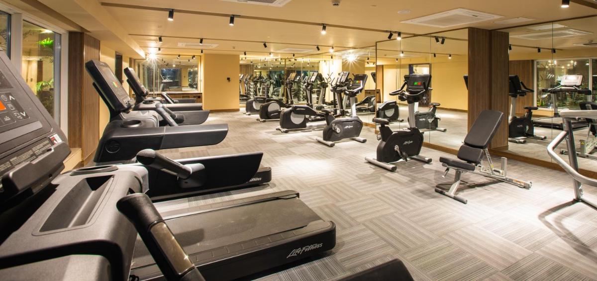 a gym with a bunch of treadmills and machines at Lemon Tree Premier City Center Pune in Pune