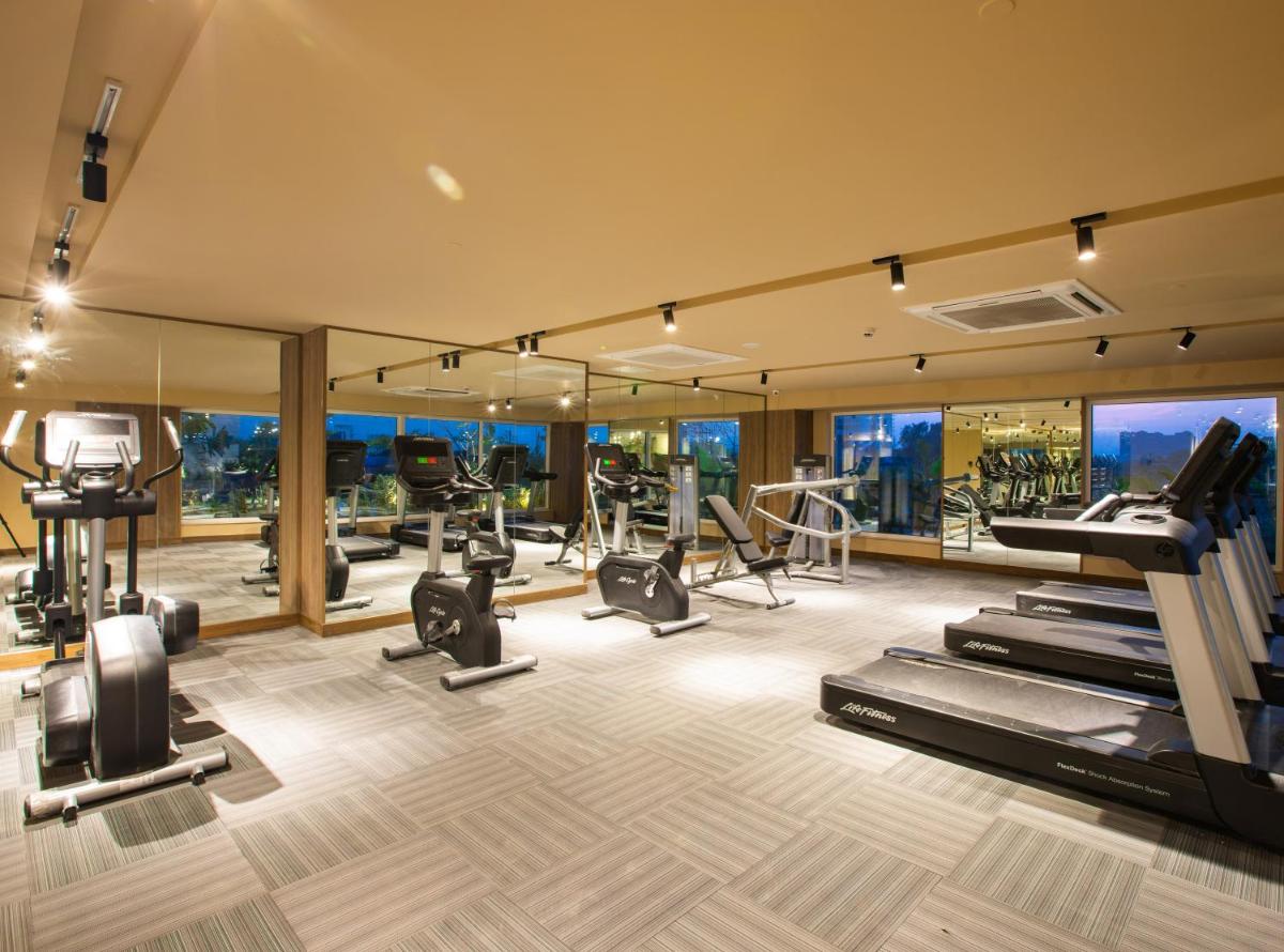 a gym with treadmills and cardio equipment in a building at Lemon Tree Premier City Center Pune in Pune