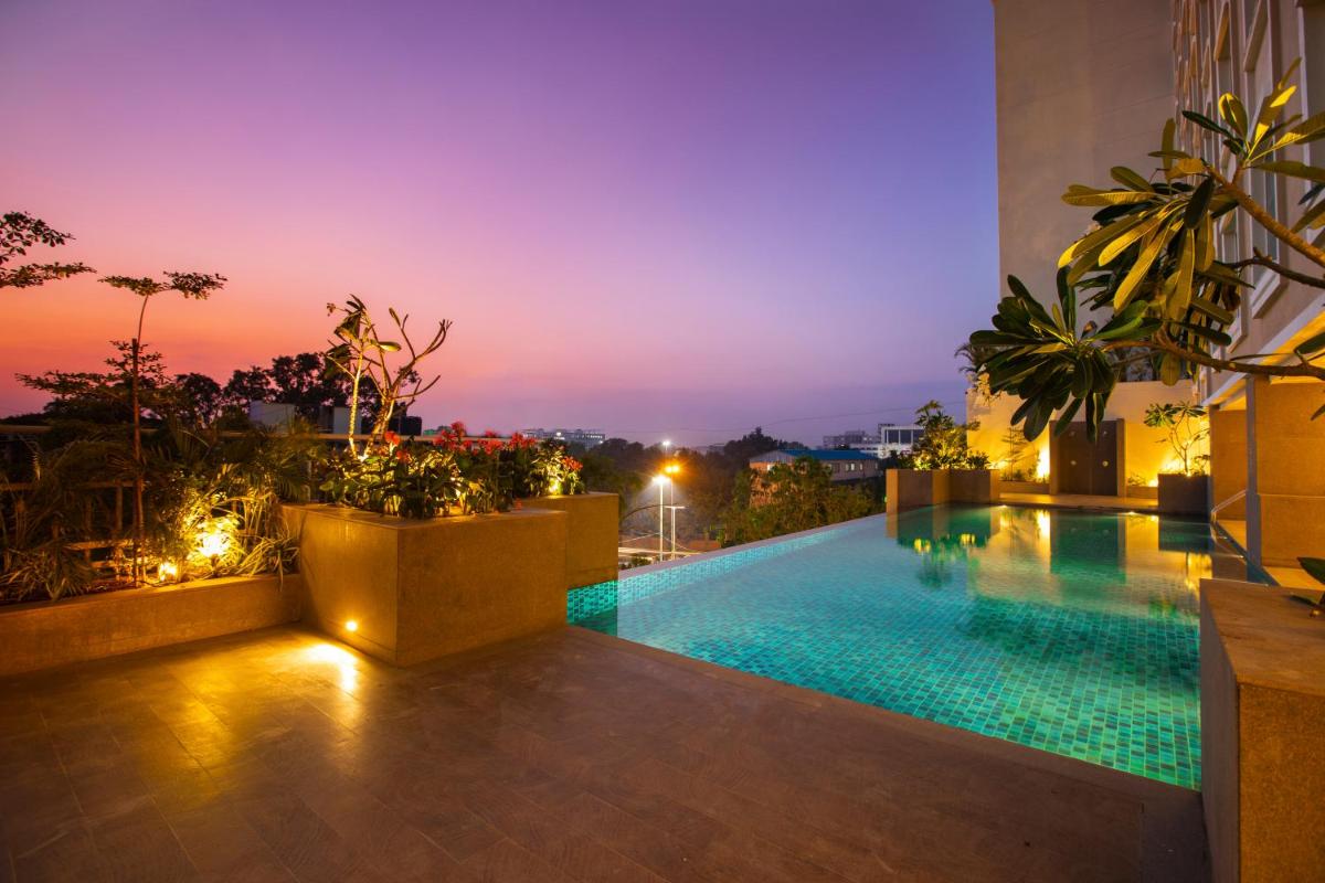 a pool on the roof of a building at night at Lemon Tree Premier City Center Pune in Pune