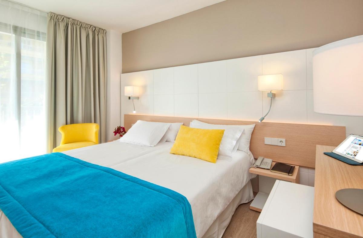 Habitación de hotel con cama con almohada amarilla en JS Palma Stay - Adults Only, en Can Pastilla