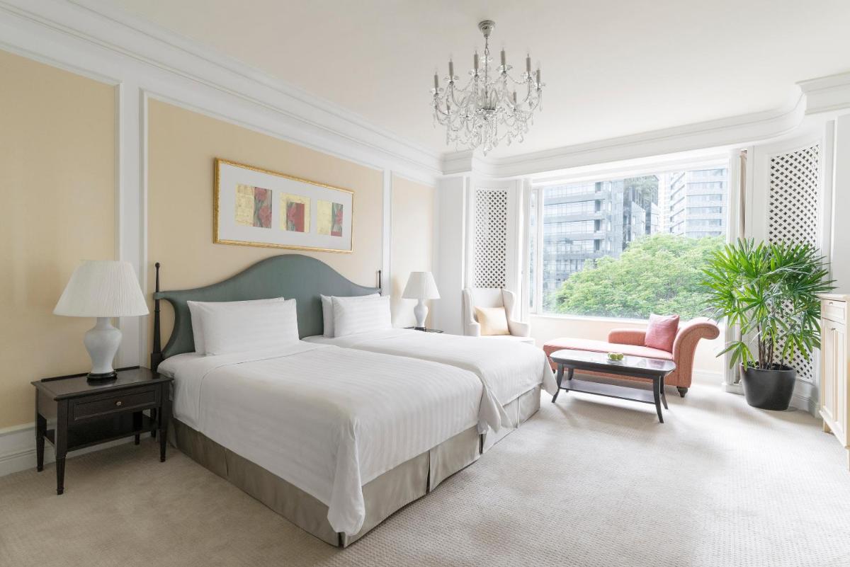 a white bedroom with a large bed and a chandelier at Shangri-La Singapore in Singapore