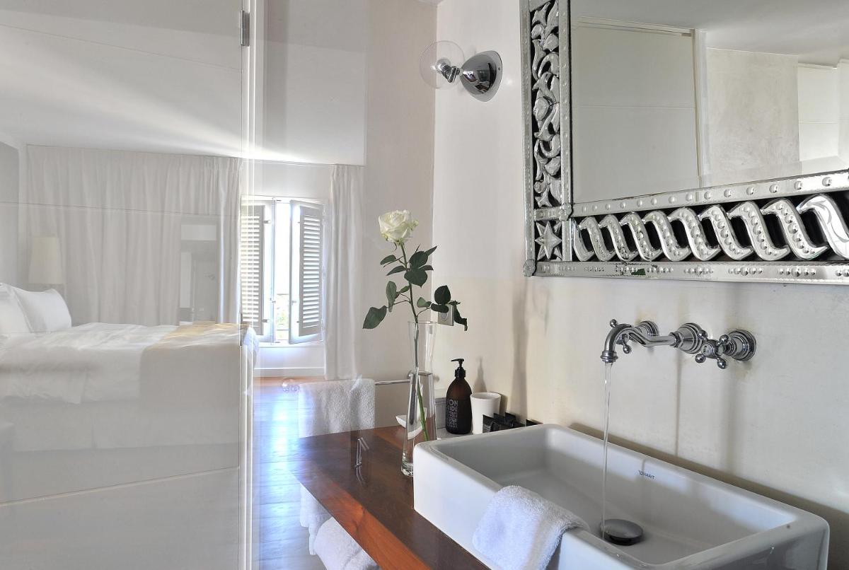 une salle de bain blanche avec un lavabo et un miroir dans l'établissement La Maison d'Aix 1785 - Hôtel Particulier & Spa, à Aix-en-Provence 15 autres photos