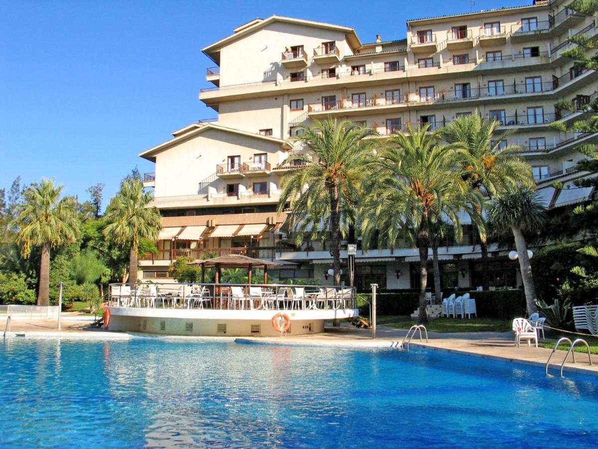 un hotel con piscina frente a un edificio en Intelier Orange, en Benicàssim