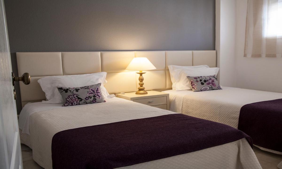 duas camas em um quarto com um abajur sobre uma mesa em Jardim do Vau em Portimão