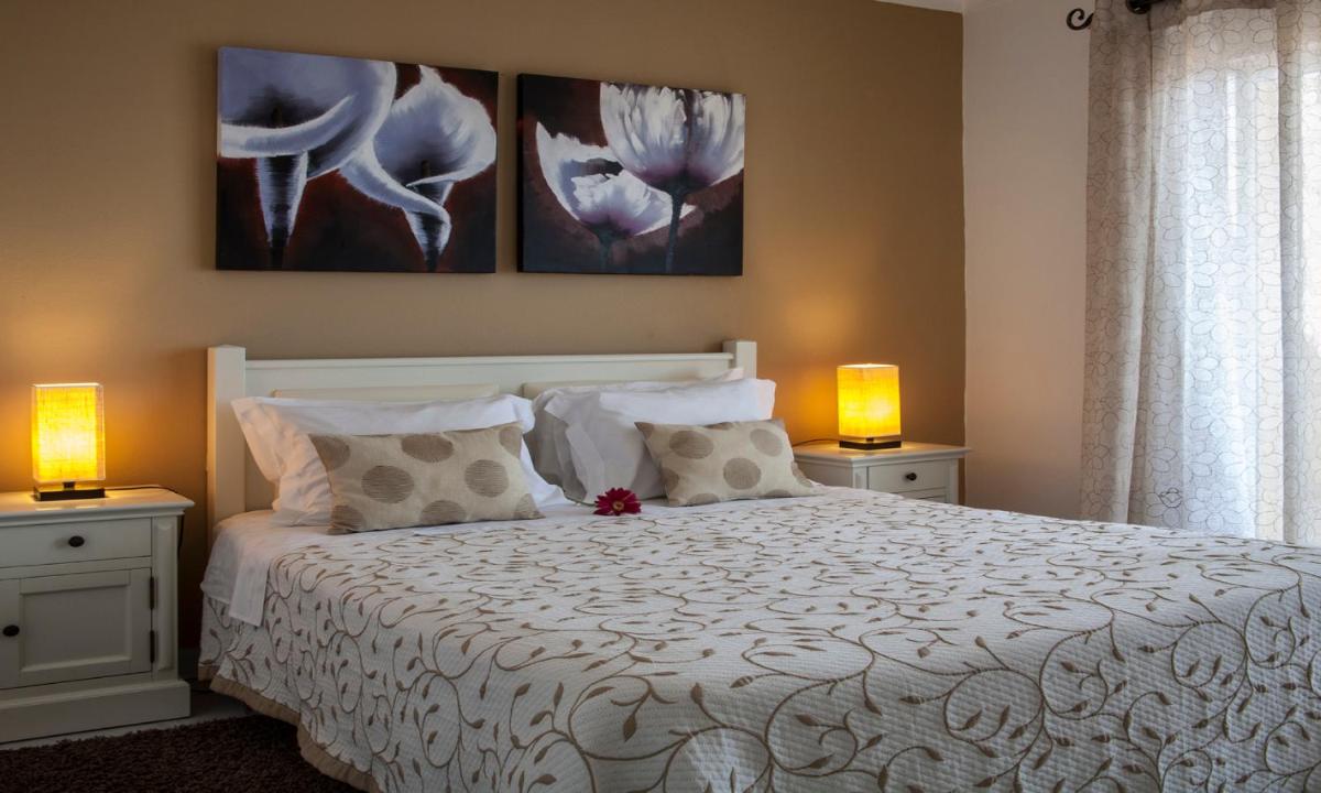 um quarto com uma cama branca com duas lâmpadas em Jardim do Vau em Portimão