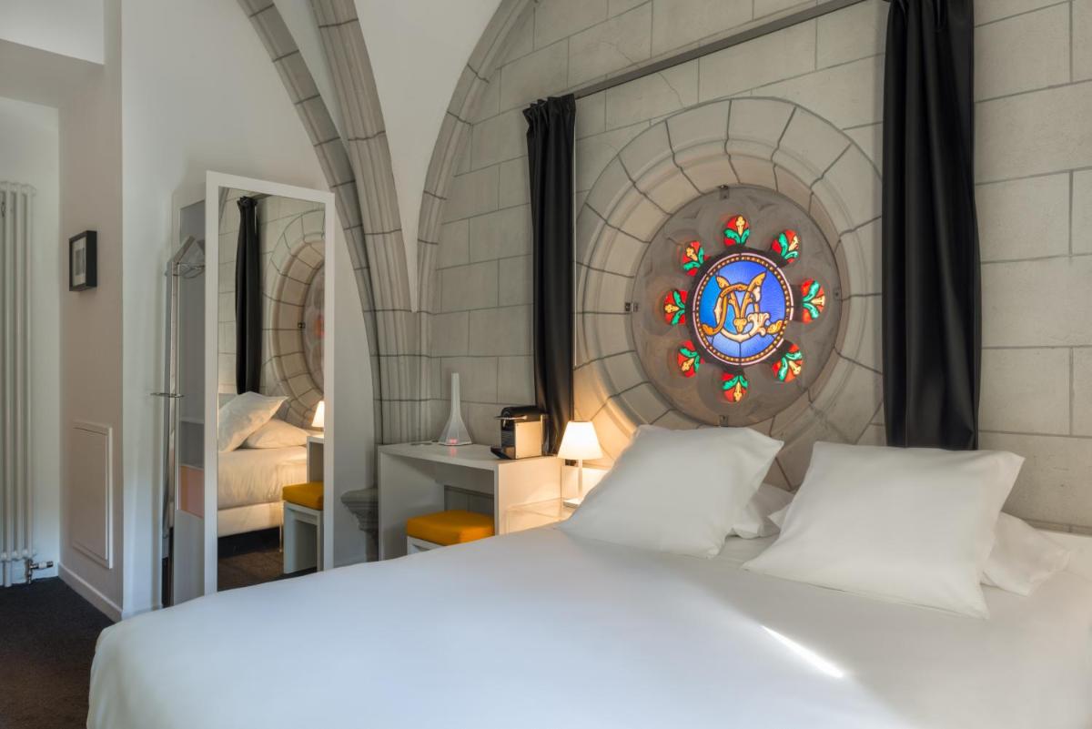 une chambre avec un lit blanc et un vitrail dans l'établissement SOZO Hotel, à Nantes