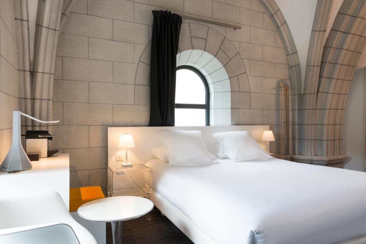 une chambre avec un grand lit blanc et une table dans l'établissement SOZO Hotel, à Nantes