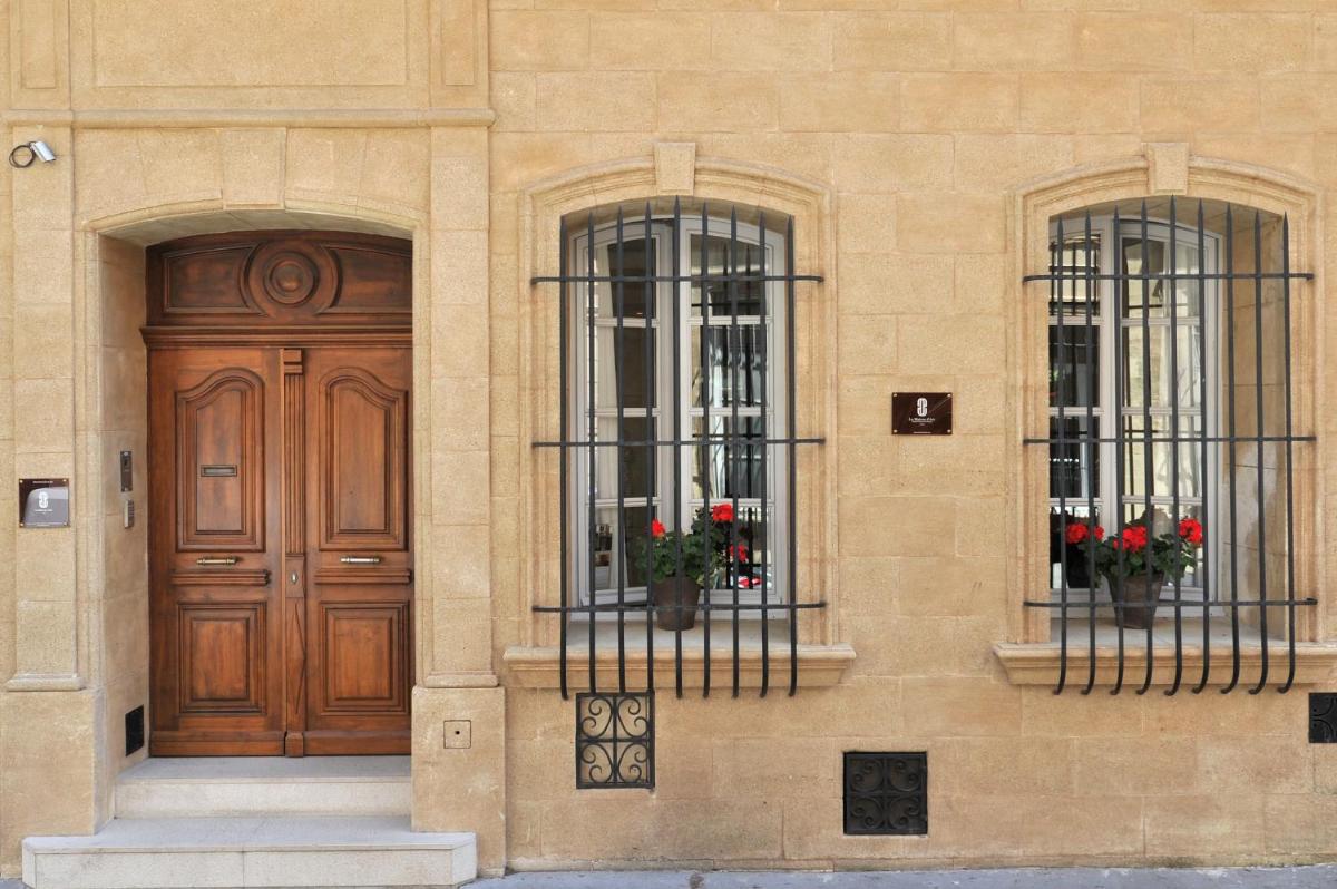 - un bâtiment avec deux fenêtres et une porte en bois dans l'établissement La Maison d'Aix 1785 - Hôtel Particulier & Spa, à Aix-en-Provence
