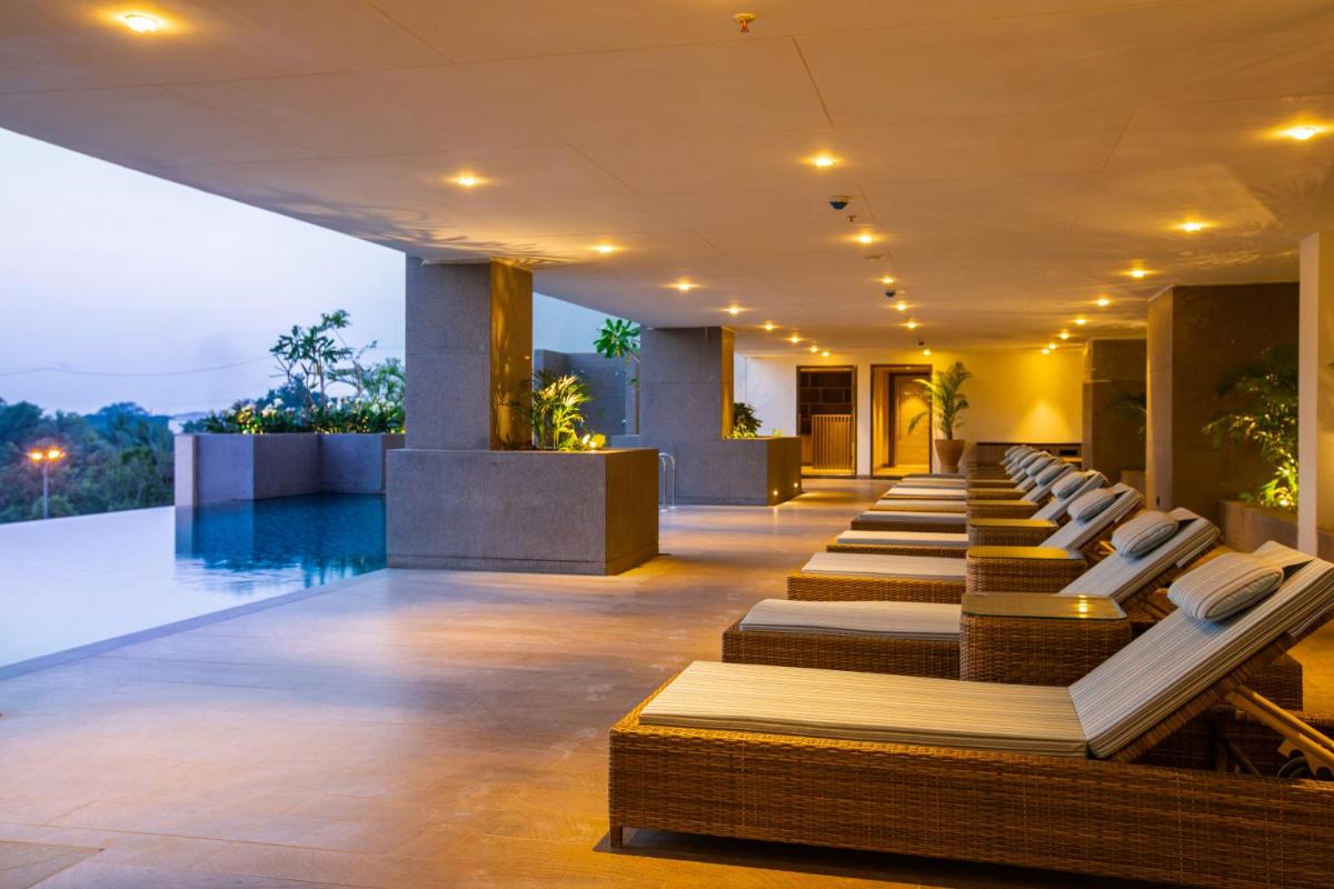 a row of chaise lounge chairs in a hotel lobby at Lemon Tree Premier City Center Pune in Pune