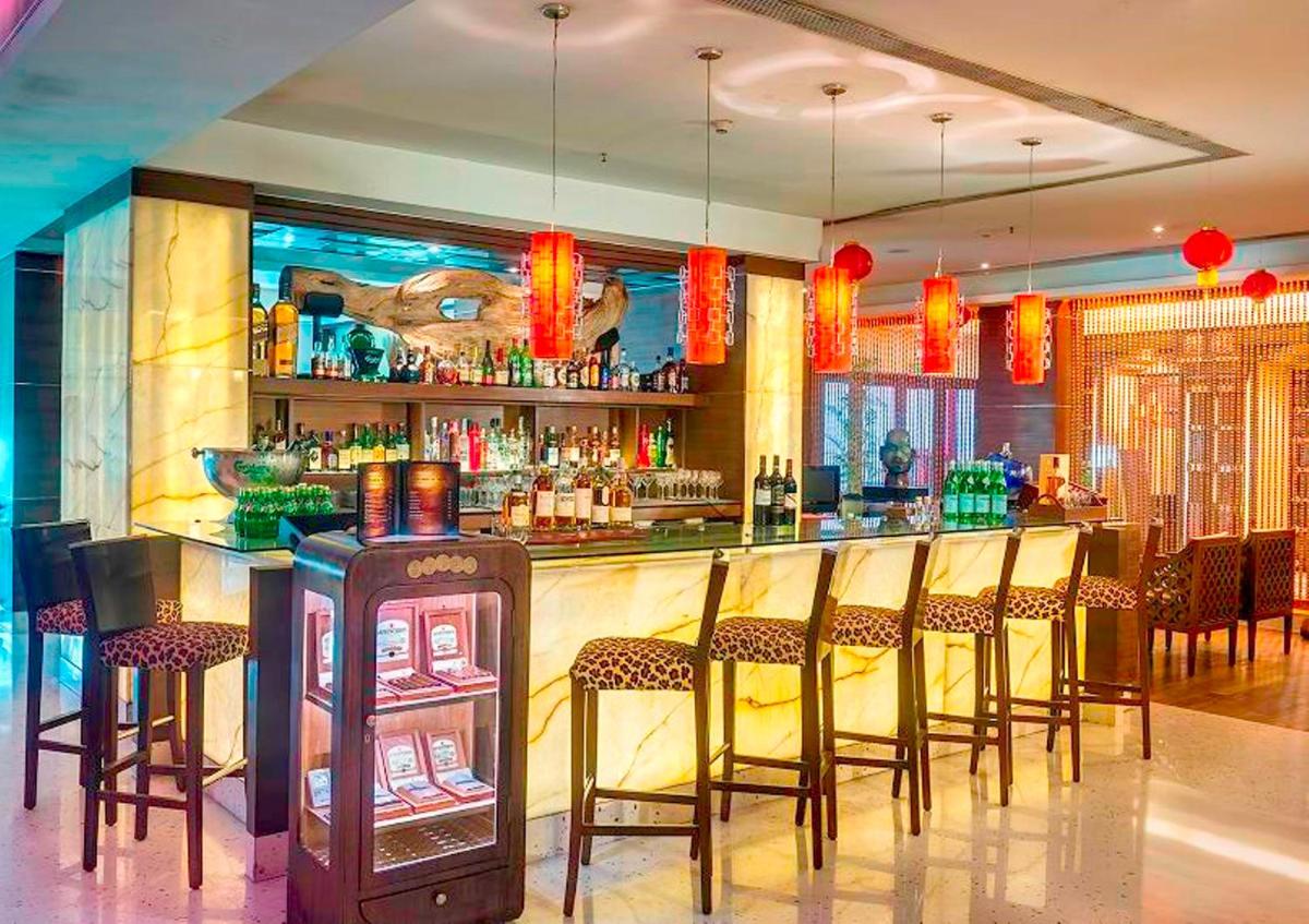 a bar with a bunch of chairs in a room at Hotel Hindusthan International, Kolkata in Kolkata