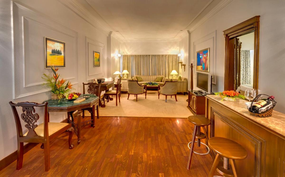 a living room with a table and a dining room at Hotel Hindusthan International, Kolkata in Kolkata