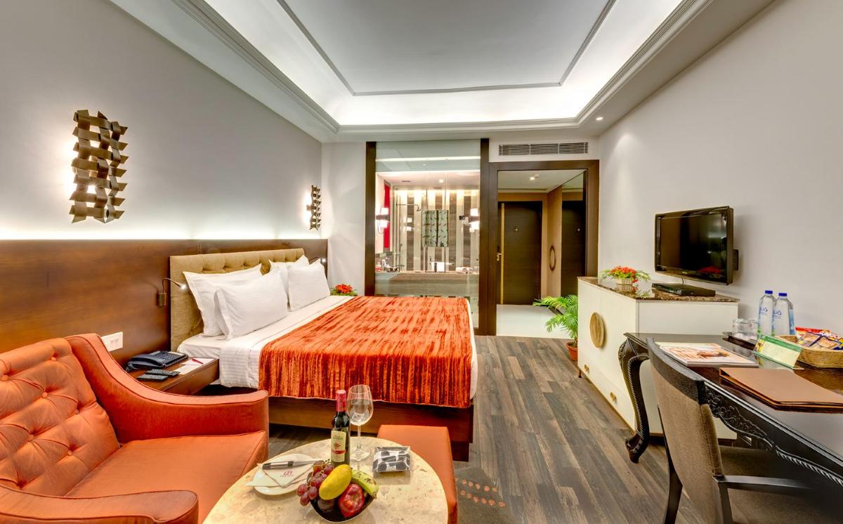 a hotel room with a bed and a couch at Hotel Hindusthan International, Kolkata in Kolkata
