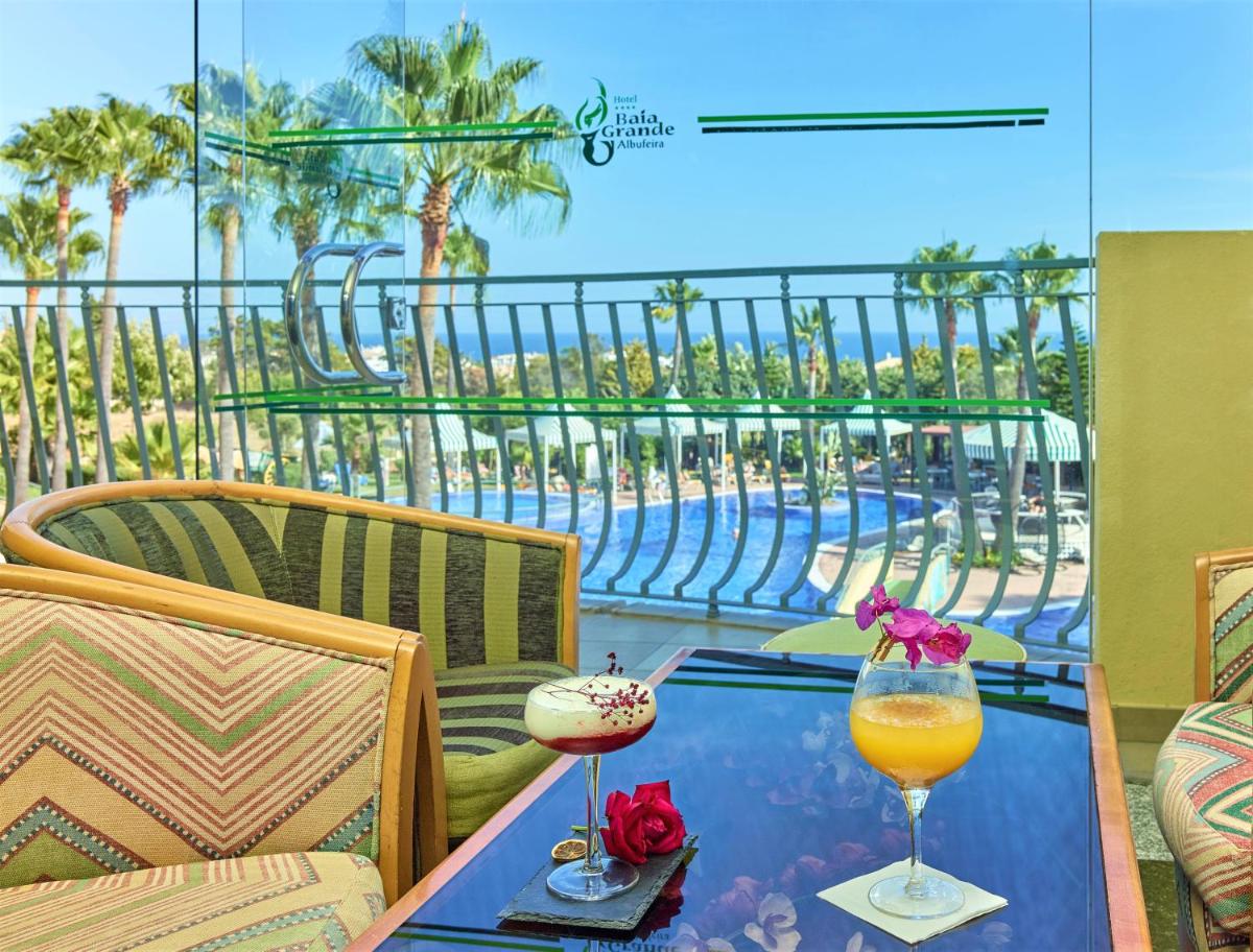 uma mesa com dois copos em cima de uma varanda em Hotel Baia Grande em Albufeira