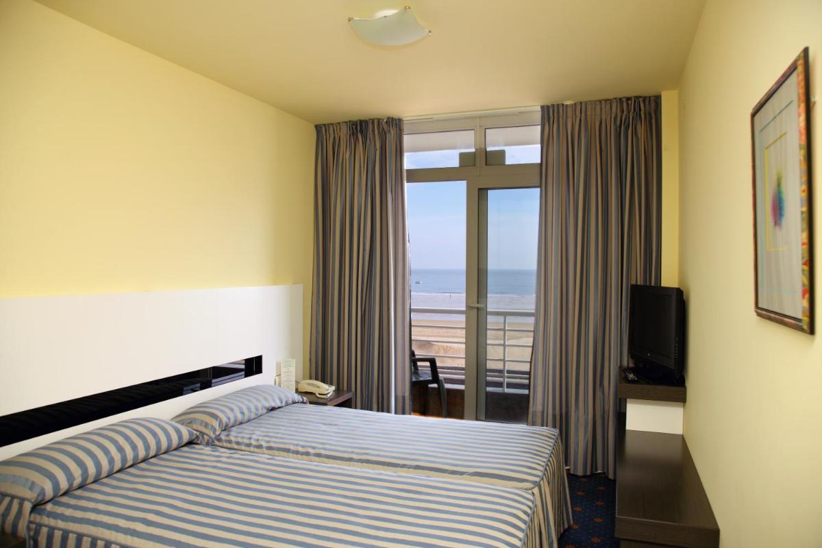 Un dormitorio con una cama con vista al mar. en Hotel Playamar Spa, en Laredo 40 fotos más