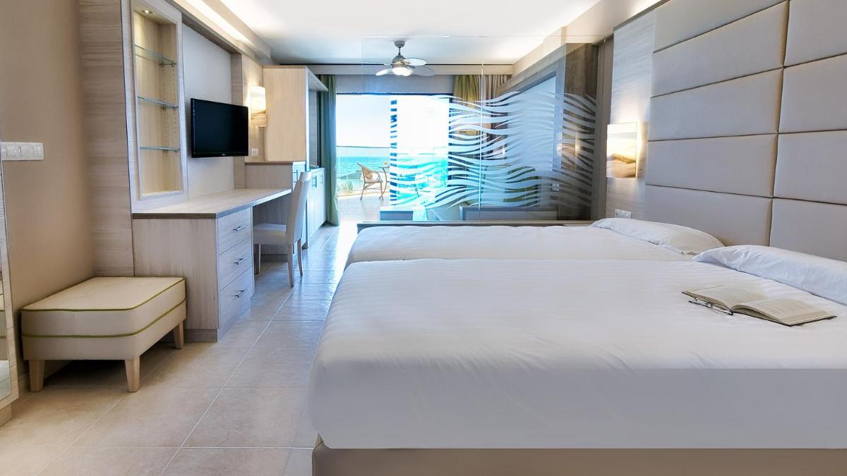 Una habitación de hotel con dos camas y un televisor. en Bull Dorado Beach & SPA, en La Playa de Arguineguín 62 fotos más