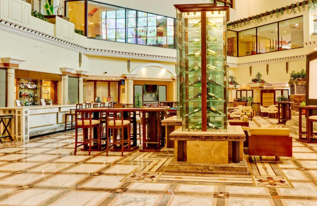 a lobby with a bar and a restaurant at The Suryaa New Delhi in New Delhi a lobby with a bar and a restaurant at The Suryaa New Delhi in New Delhi