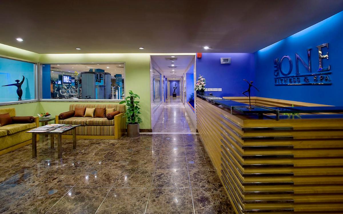 a lobby with blue walls and couches in a store at The Suryaa New Delhi in New Delhi a lobby with blue walls and couches in a store at The Suryaa New Delhi in New Delhi