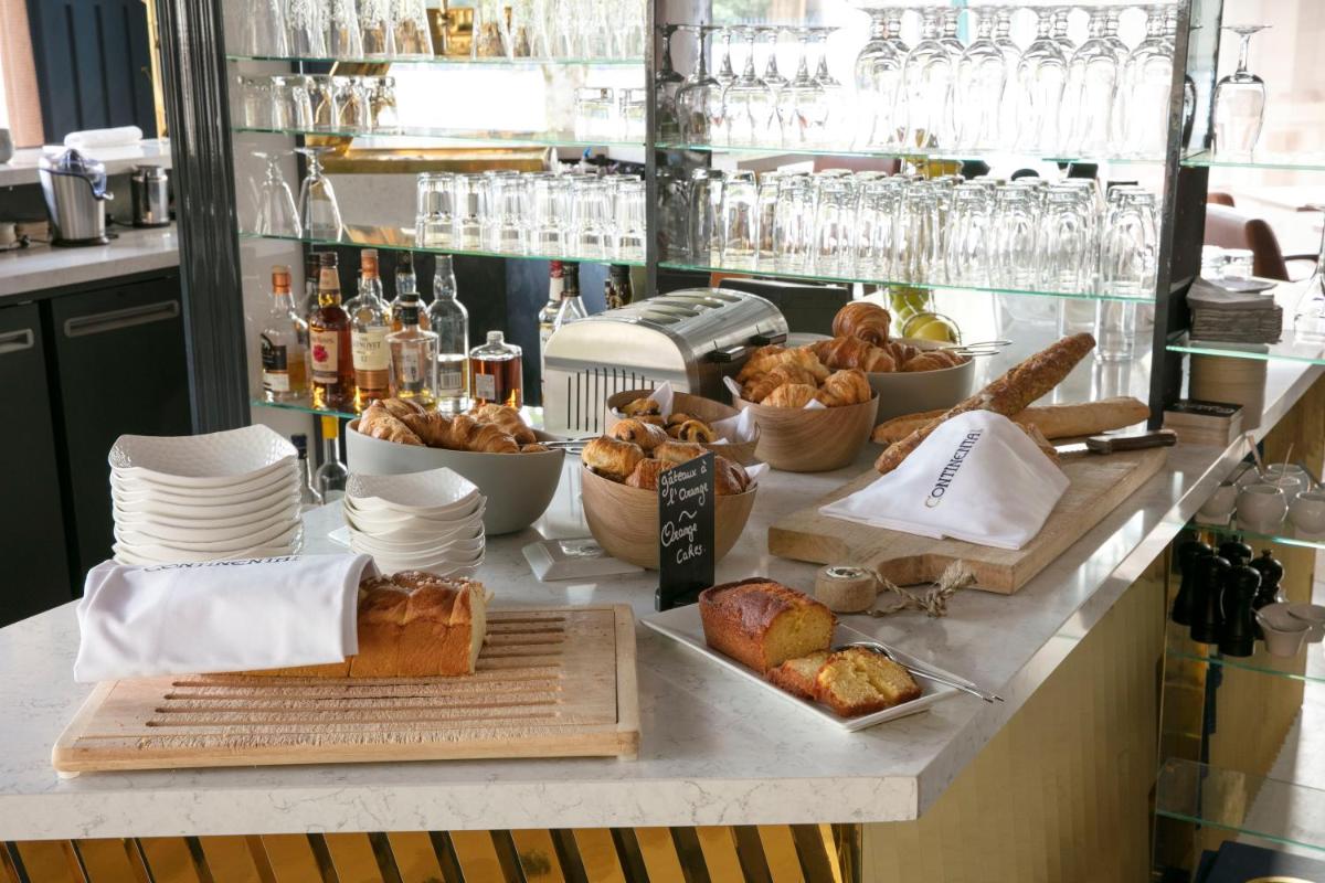 - un buffet composé de pain et de viennoiseries sur un comptoir dans l'établissement Continental Hotel, à Reims