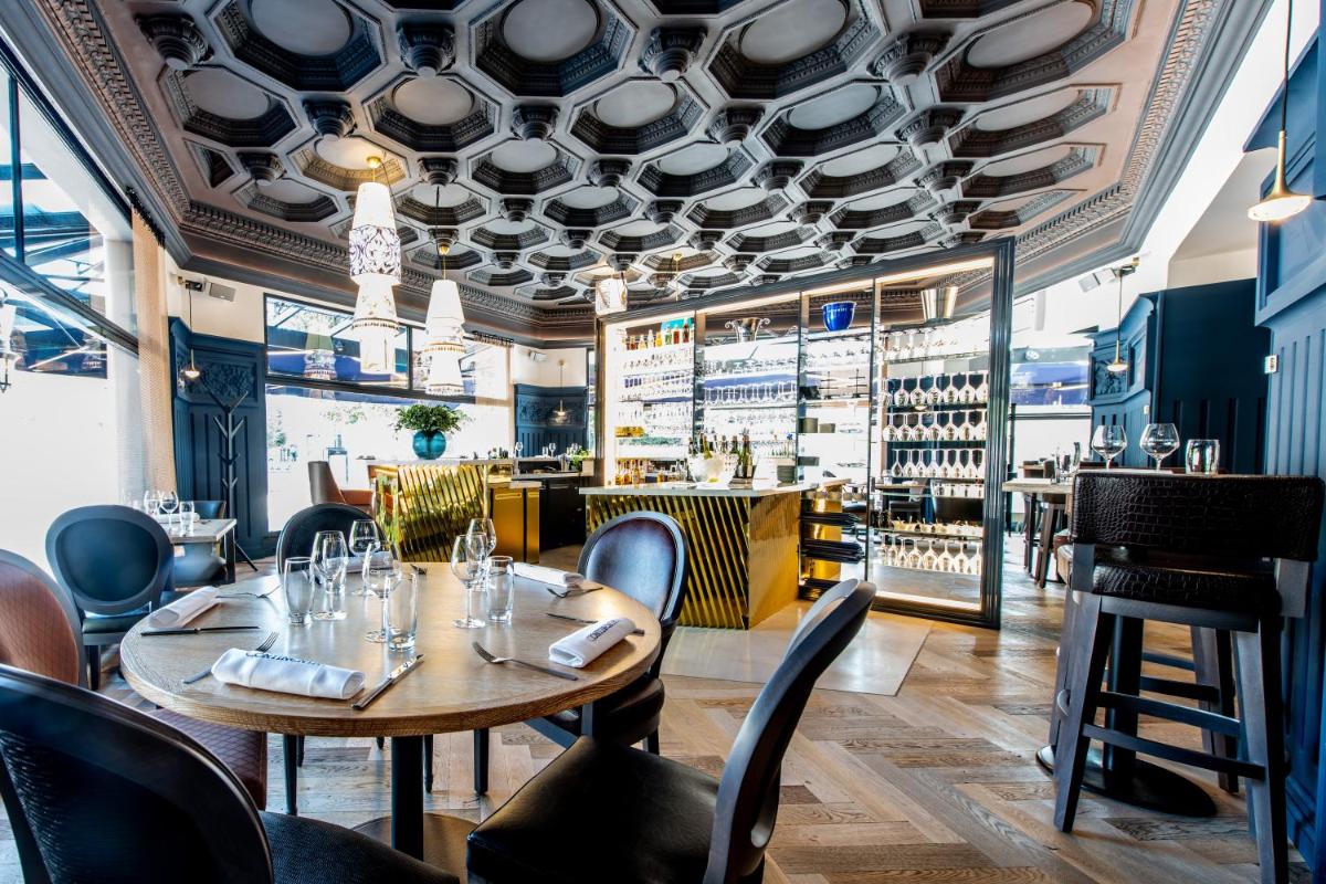 un restaurant avec des tables et des chaises et un bar dans l'établissement Continental Hotel, à Reims