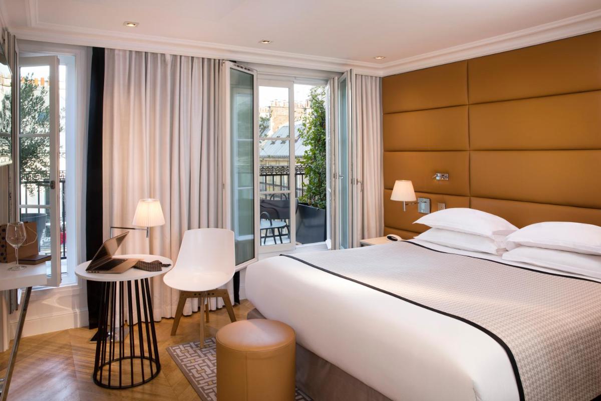 une chambre avec un grand lit et un balcon dans l'établissement Hôtel R de Paris - Boutique Hotel, à Paris