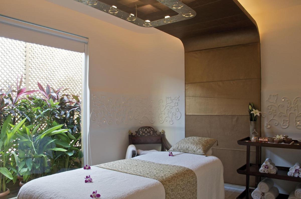 two beds in a room with a window at President - IHCL SeleQtions in Mumbai