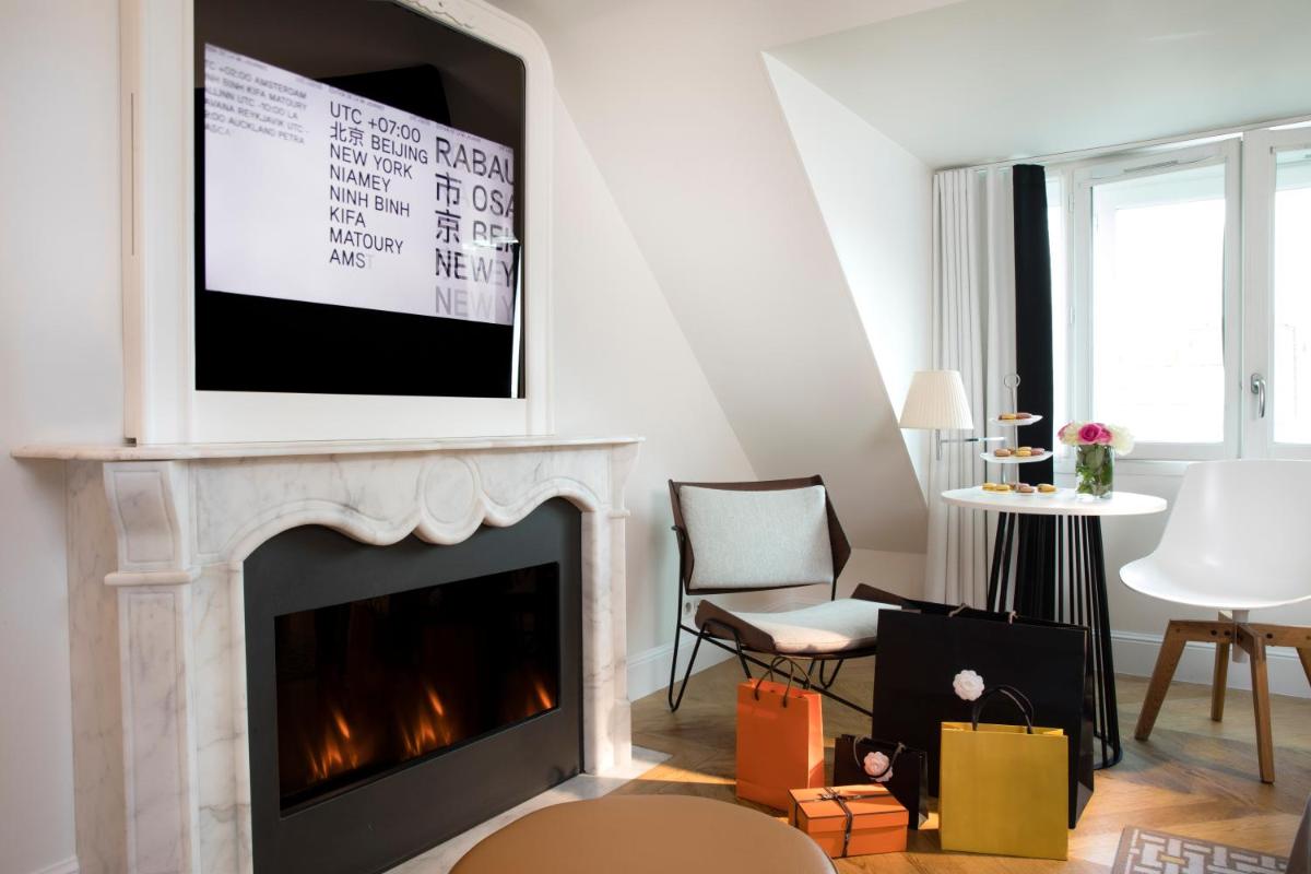 un salon avec une cheminée et une télévision dans l'établissement Hôtel R de Paris - Boutique Hotel, à Paris
