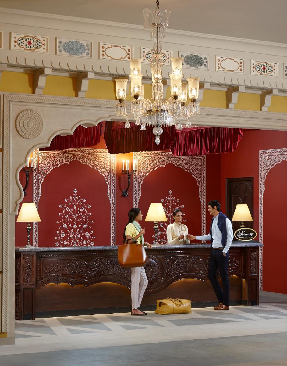 a man and a woman standing in front of a counter at Fairmont Jaipur in Jaipur