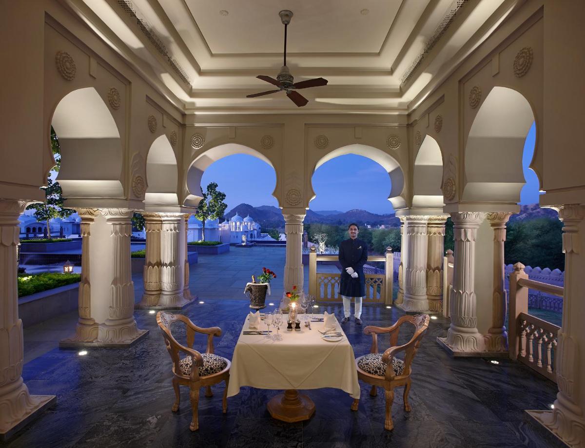 a dining room with a table and a person standing in the middle at Fairmont Jaipur in Jaipur