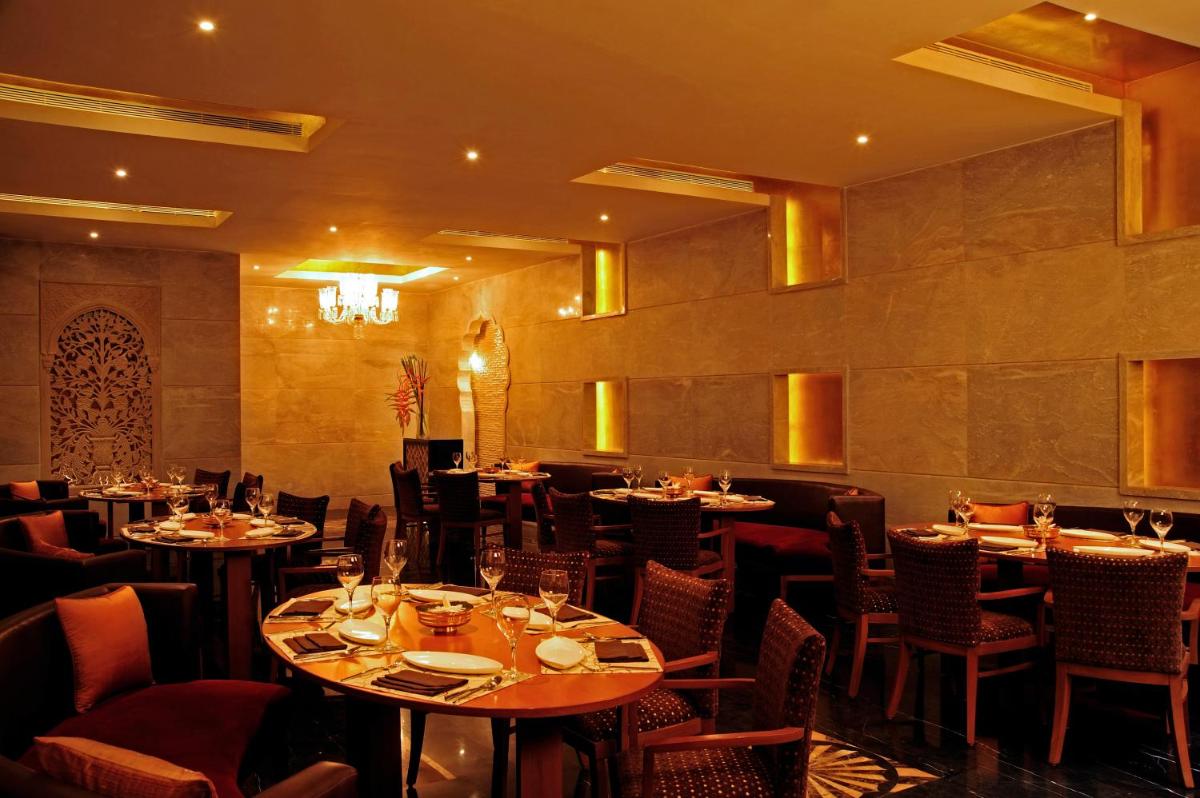 a restaurant with tables and chairs in a room at Taj Club House in Chennai
