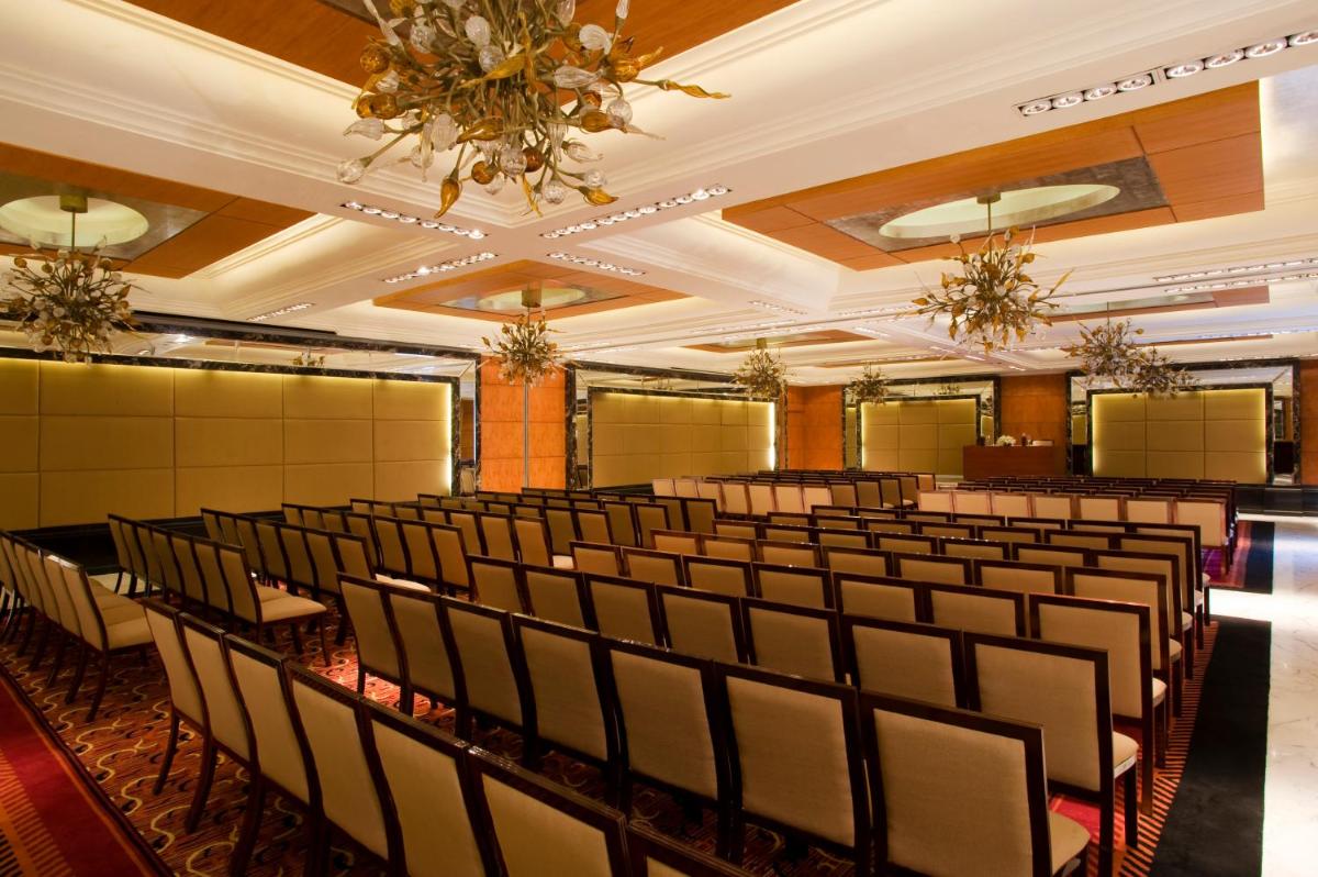 a room with rows of chairs and a chandelier at Taj Club House in Chennai +35 photos