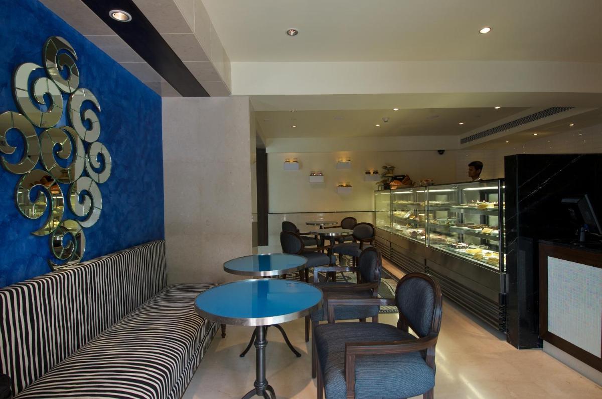 a restaurant with tables and chairs and a counter at Blue Diamond Pune IHCL SeleQtions in Pune